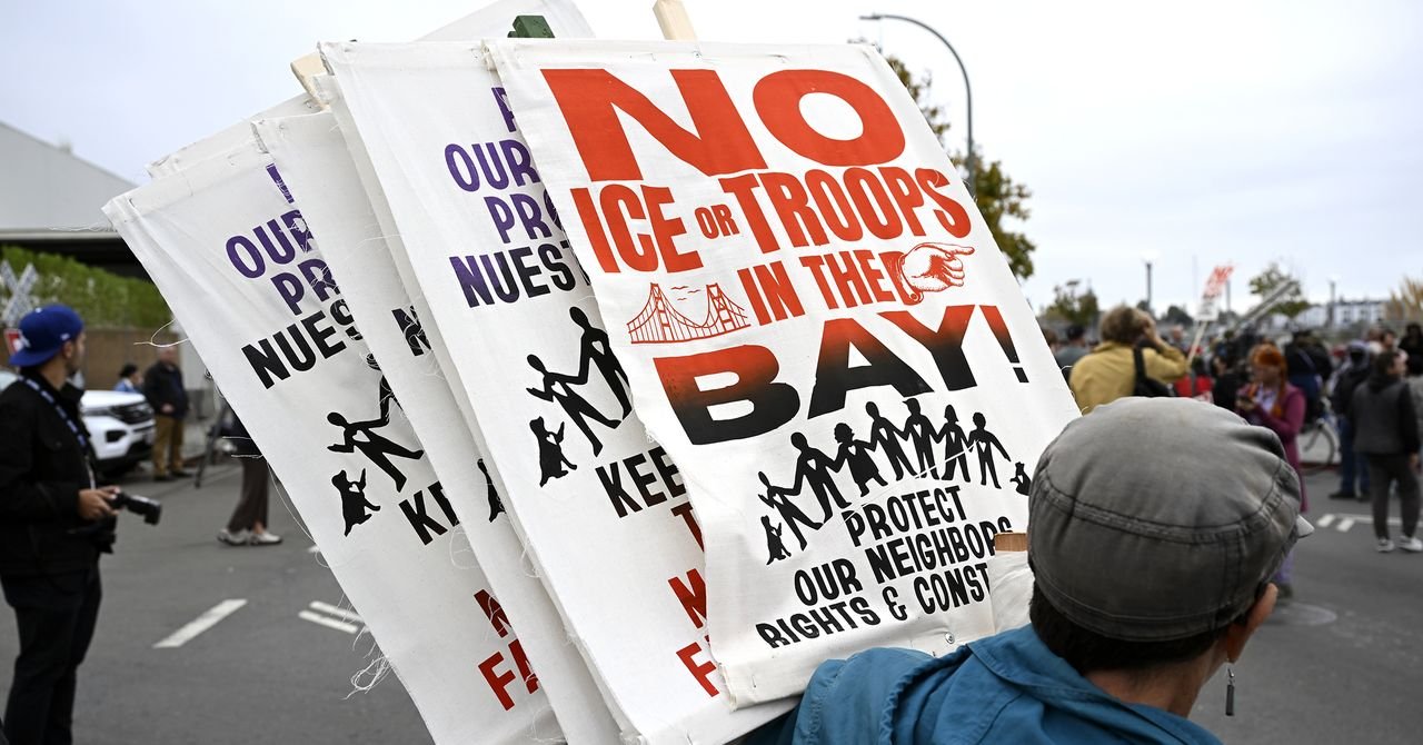 Tech workers protesting or holding signs against ICE actions, with a backdrop of a tech company building.