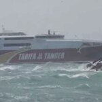 Un ferry luttant contre de fortes vagues dans le Détroit de Gibraltar, sous un ciel orageux, symbolisant la suspension du trafic maritime due à la tempête Kristin.