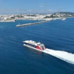 Vue du port d'Algésiras avec des navires et des grues, sous un ciel nuageux et agité, symbolisant la reprise partielle du trafic après les intempéries.