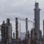 Donald Trump speaking, with an oil rig or a map of Venezuela in the background, symbolizing his interest in the country's oil reserves.