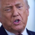 President Donald Trump and South Korean President Moon Jae-in shaking hands, with a backdrop of flags, symbolizing complex diplomatic and trade relations.