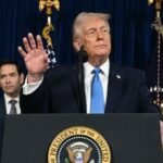 US President Donald Trump speaks to the press as Secretary of State Marco Rubio looks on following US military actions in Venezuela.