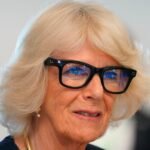 A person wearing futuristic augmented reality glasses, with digital information overlaid on their view of the real world