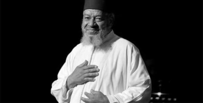 Portrait en noir et blanc d'Abdelhadi Belkhayat, chanteur marocain, souriant et élégant.