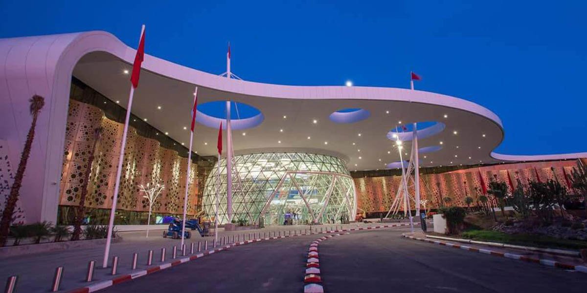 Vue aérienne d'un aéroport moderne au Maroc avec des avions et des terminaux élégants, symbolisant le contraste entre l'architecture et les défis opérationnels de l'expérience passager.