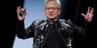Nvidia CEO Jensen Huang speaking at a tech conference, with a backdrop of server racks or AI chips.