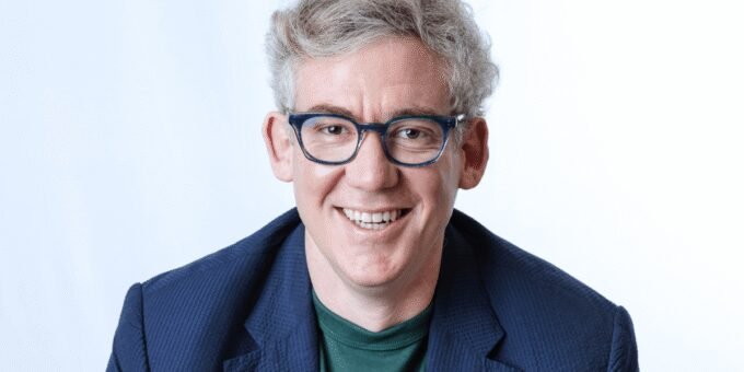 A CEO standing in a modern manufacturing facility, looking at air filters, with digital interfaces subtly visible in the background, symbolizing the integration of AI in traditional industries.