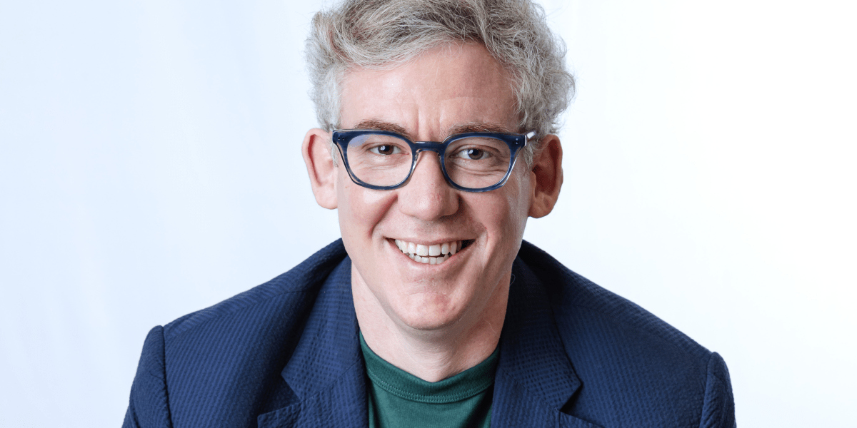 A CEO standing in a modern manufacturing facility, looking at air filters, with digital interfaces subtly visible in the background, symbolizing the integration of AI in traditional industries.