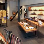 A stylized image depicting AI algorithms interacting with fashion sketches and luxury handbags, representing technology and design.