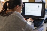 An abstract image depicting artificial intelligence influencing a job interview process, perhaps with a robot hand shaking a human hand, or AI symbols integrated into a resume.