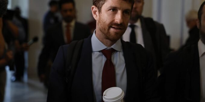 Artificial intelligence robot hand reaching towards a human hand, symbolizing the impact of AI on human labor and the job market.