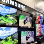 A smart TV screen displaying AI-related graphics with memory chips in the background, symbolizing the impact of AI on TV prices.