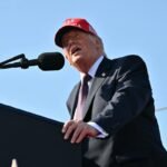 US President Donald Trump speaking at a podium, with the Port of Corpus Christi in the background.
