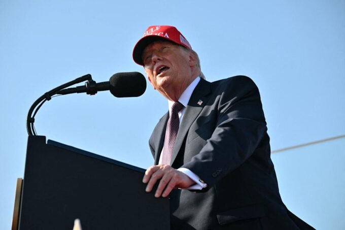US President Donald Trump speaking at a podium, with the Port of Corpus Christi in the background.