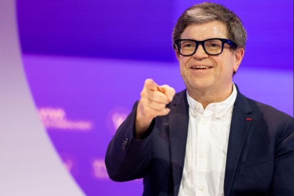 Yann LeCun, a prominent AI researcher, stands in front of a digital display, symbolizing the future of artificial intelligence.