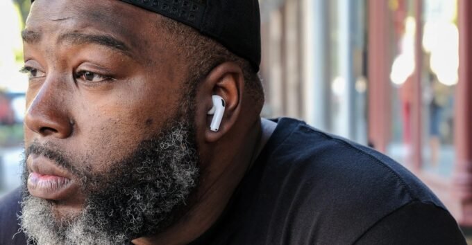 An Apple AirPods 4 earbud resting on a surface, highlighting its sleek design and wireless capabilities.