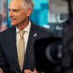 Robert Isom, CEO of American Airlines, standing confidently in front of an American Airlines aircraft.
