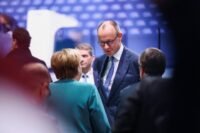 Angela Merkel et Friedrich Merz s'entretiennent lors du congrès de la CDU à Stuttgart en 2026.