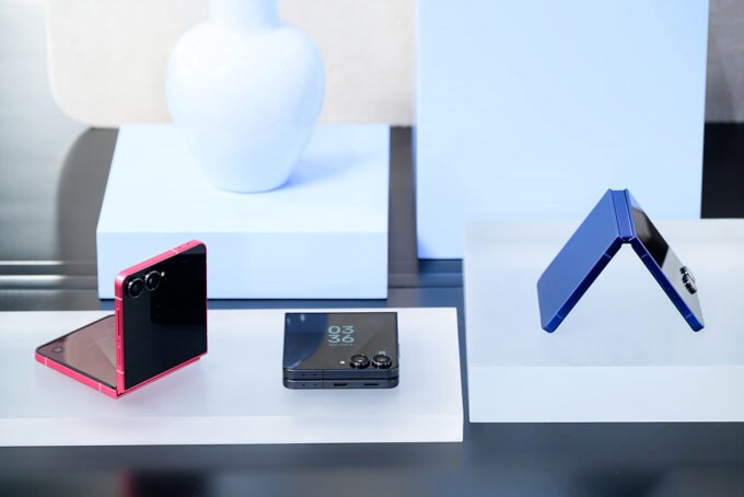 A conceptual rendering of a foldable iPhone in a clamshell design, possibly next to other foldable smartphones.