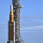 NASA's Space Launch System (SLS) rocket being rolled back to the Vehicle Assembly Building for repairs, delaying the Artemis II moon mission.