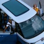 A football field with a car logo subtly integrated into the background, symbolizing the automotive industry's presence (or lack thereof) at the Super Bowl.