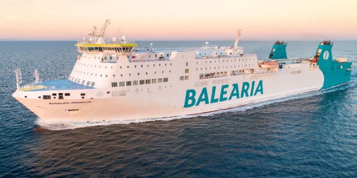 A modern Baleària fast ferry navigating the blue waters of the Strait of Gibraltar with the Moroccan coastline visible in the distance.