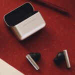 Bang & Olufsen Beo Grace wireless earphones, showcasing their minimalist cylindrical design and elegant charging case.