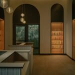 Exterior view of BASIN Glacial Waters thermal spa at Fairmont Chateau Lake Louise, showing arched windows and glacial backdrop.