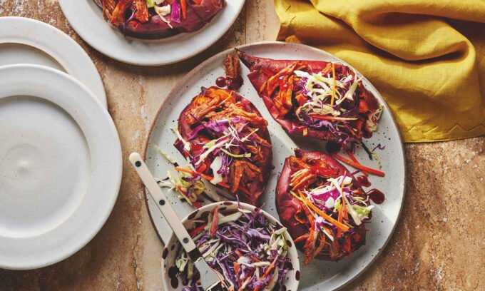 The Ultimate Weeknight Feast: BBQ Pulled Pork Stuffed Sweet Potatoes 10 A close-up of a halved baked sweet potato generously stuffed with BBQ pulled pork and topped with creamy coleslaw, served on a plate.