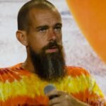 Block CEO Jack Dorsey speaking, with a stock chart showing a sharp increase in the background.