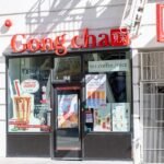 A Bubble Bliss boba tea store sign positioned closely to a Starbucks coffee shop, illustrating a strategic co-location business model.