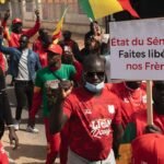 Des supporters sénégalais manifestent à Dakar, brandissant des pancartes 'Libérez les otages', en soutien aux 18 fans emprisonnés au Maroc après la finale de la CAN.