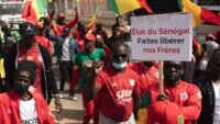 Des supporters sénégalais manifestent à Dakar, brandissant des pancartes 'Libérez les otages', en soutien aux 18 fans emprisonnés au Maroc après la finale de la CAN.