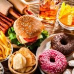 Maroc : Le Fast-Food, un Facteur Alarmant dans l'Émergence du Cancer Colorectal Précoce 4 Un burger et des frites, symboles de la restauration rapide, posés sur une table, évoquant les risques pour la santé.