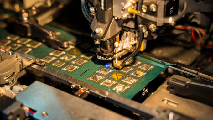 A robotic machine manufacturing a semiconductor chip, displayed for investors at an investment summit.