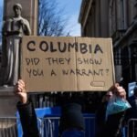 Protesters holding anti-ICE signs outside Columbia University after a student's detention.