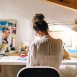 Hand operating a computer mouse on a desk, illustrating the common contact point for germs.