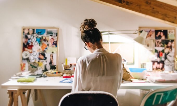 Hand operating a computer mouse on a desk, illustrating the common contact point for germs.