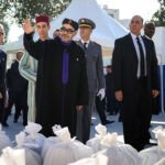 Sa Majesté le Roi Mohammed VI, accompagné de SAR le Prince Héritier Moulay El Hassan, lance l'opération nationale Ramadan 1447 à Salé, remettant symboliquement des paniers alimentaires à des familles bénéficiaires, entouré de bénévoles.