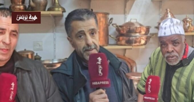 صورة لورشة نحاس تقليدية بفاس تظهر الحرفيين وهم يعملون على قطع النحاس أو منتجات نحاسية جاهزة.