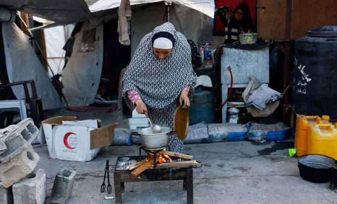 صورة تظهر نازحين في خان يونس يستخدمون الحطب للطهي وسط نقص غاز الطهي.