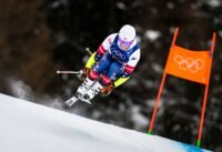 متزلج ينحدر بسرعة على منحدر جليدي خلال تدريبات أولمبياد ميلانو-كورتينا 2026 الشتوية.