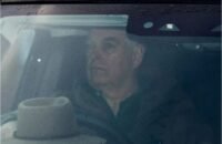 صورة للأمير أندرو مع خلفية تظهر سيارات الشرطة البريطانية