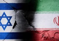 صورة توضيحية لصحفي أمام مبنى أمني إسرائيلي، ترمز إلى التحقيقات الأمنية الجارية.