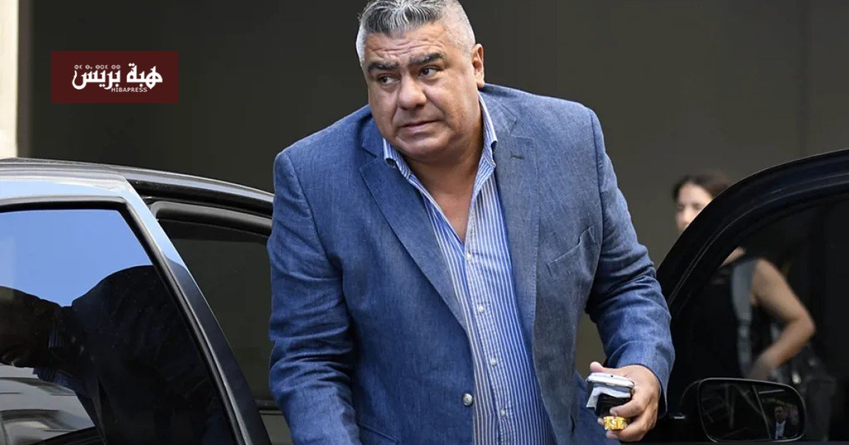 صورة لكلاوديو تابيا، رئيس الاتحاد الأرجنتيني لكرة القدم، أمام مبنى محكمة أو مقر الاتحاد.