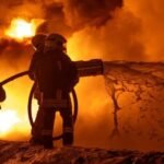 صورة تظهر رجل إطفاء أوكراني يكافح حريقاً في أوديسا بعد ضربة بطائرة مسيرة روسية.