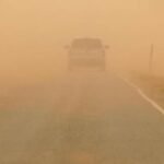 صورة توضيحية لأجواء مغبرة في الأردن مع سماء ملبدة بالرمال وأشعة شمس قوية.