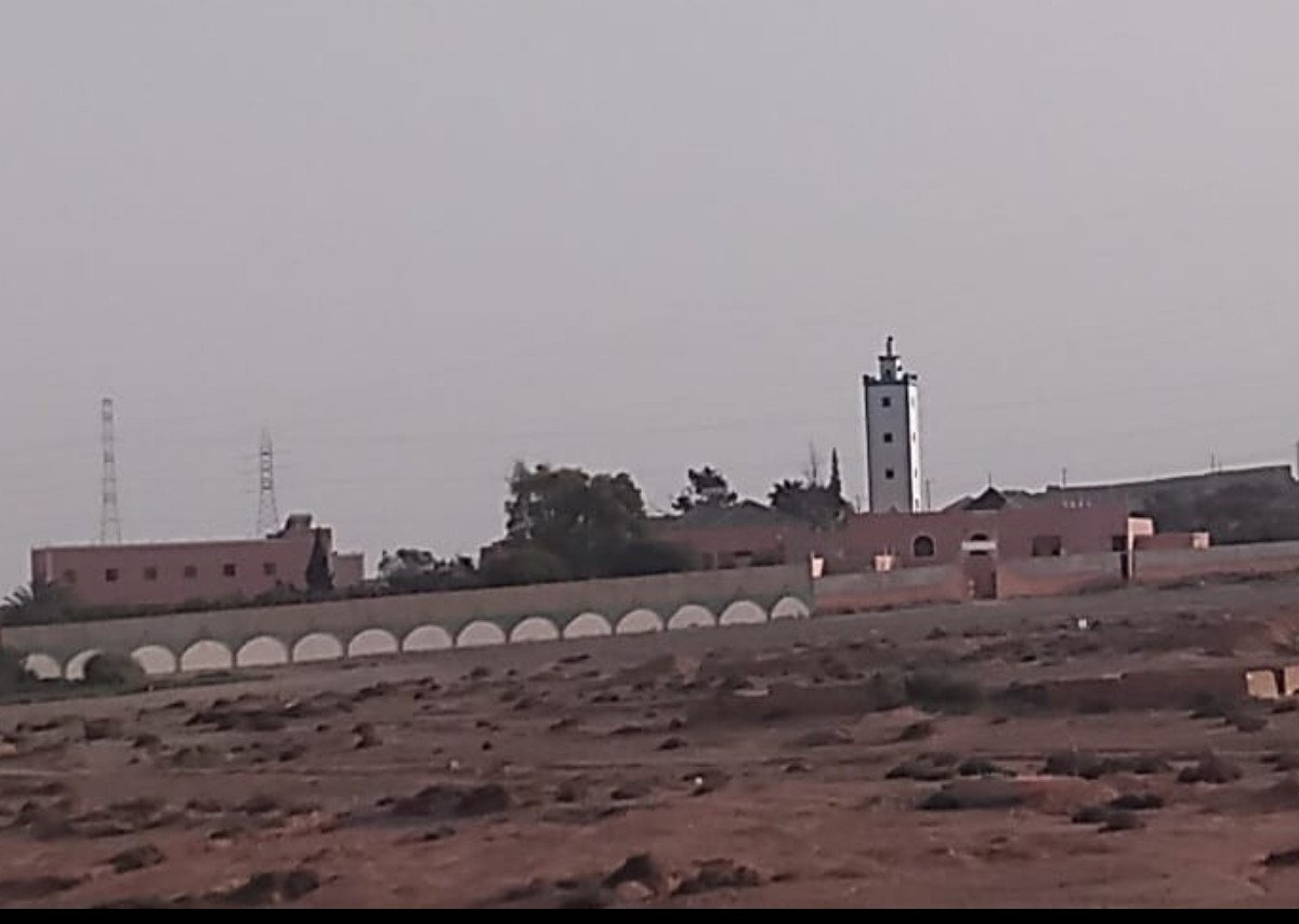 صورة للمدرسة العتيقة الرحمة بأيت ياسين، تظهر عمارتها التقليدية وطلابها، رمزاً لاستمرارية التعليم الأصيل في الجنوب المغربي.