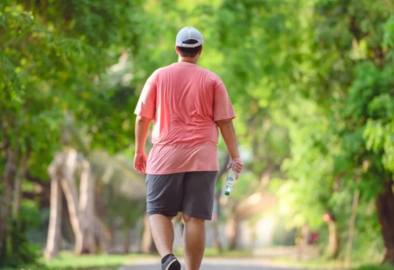 دراسة علمية تكشف: المشي لأكثر من 5000 خطوة يومياً درع واقٍ ضد التدهور المعرفي والزهايمر 3 شخص يمشي في حديقة خضراء، يرمز إلى النشاط البدني وفوائده لصحة الدماغ والوقاية من الزهايمر.