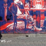 جدارية في طهران تصور طاولة مفاوضات، تعكس التوترات الدبلوماسية بين إيران والولايات المتحدة.